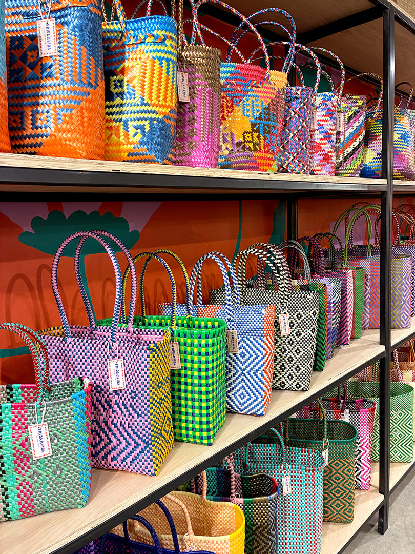 Shelves displaying a variety of colorful handwoven bags with geometric patterns.