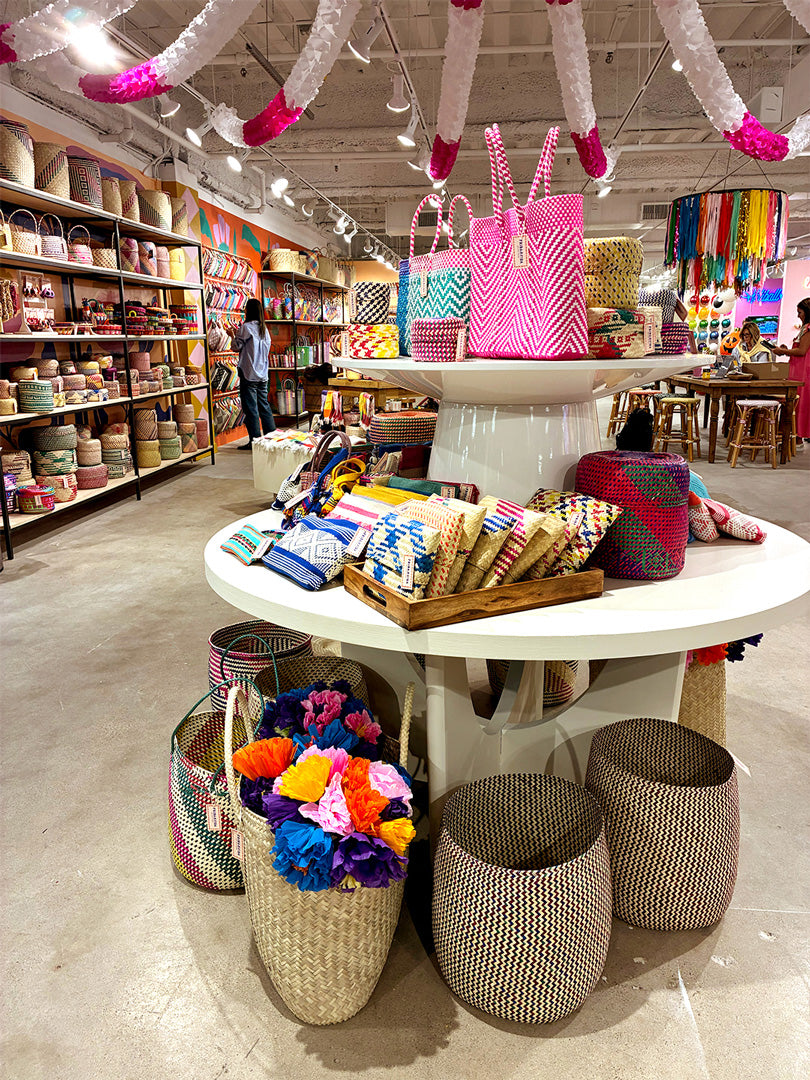 Store interior with colorful bags and decor items on a central table.